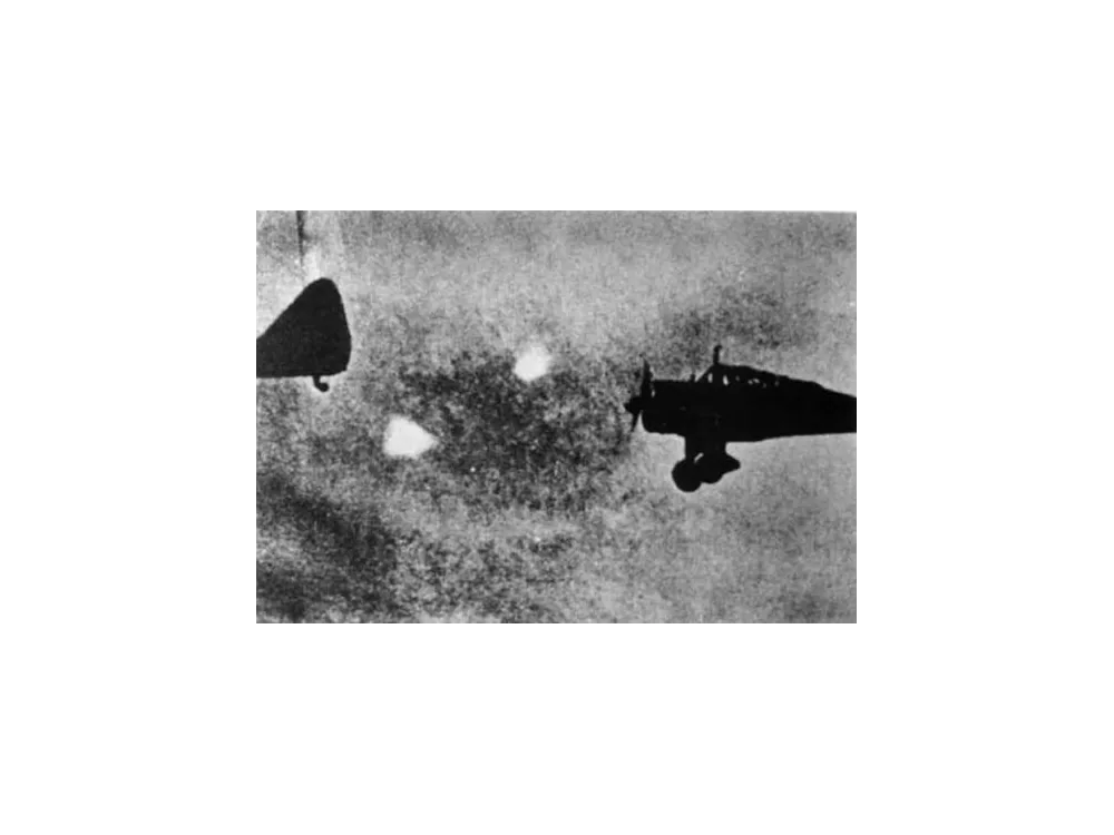 Wartime photograph of two aircraft with bright round lights between them.